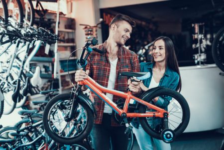 parents looking at childs bike before buying it
