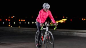 a woman riding her bicycle at night