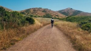Man riding his hybrid bike down the dirt trails