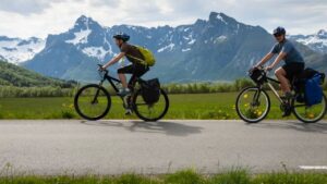 two mountain bikes being ridden on the road