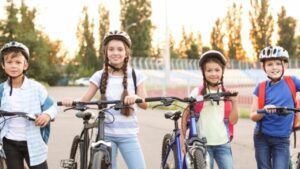 children standing next to their bikes