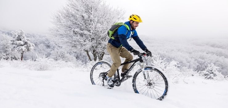 a man having fun riding his mountain bike in the snow