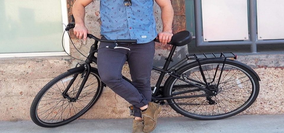 a man posing on his hybrid bike in the street
