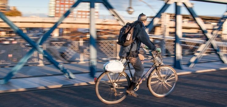 a man riding a hybrid bicycle through the city