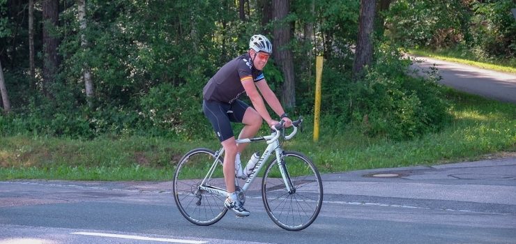 a man riding his bicycle on the road
