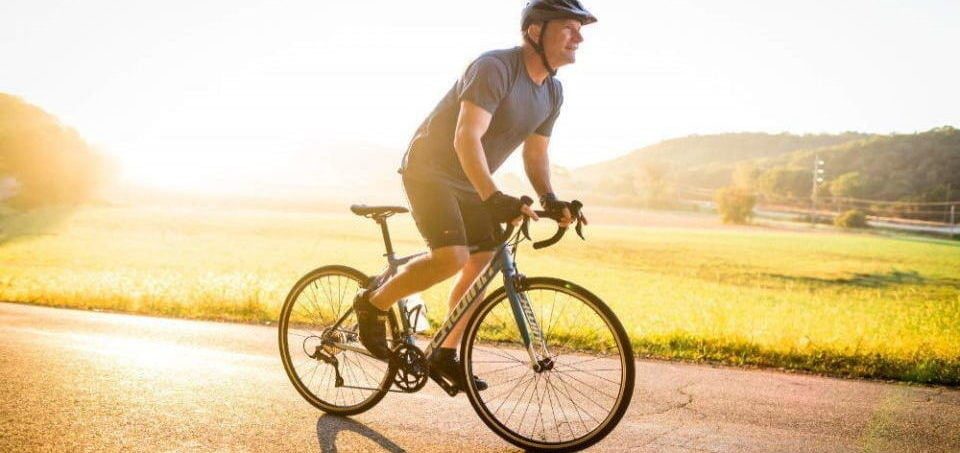 a man riding his bike at sunset