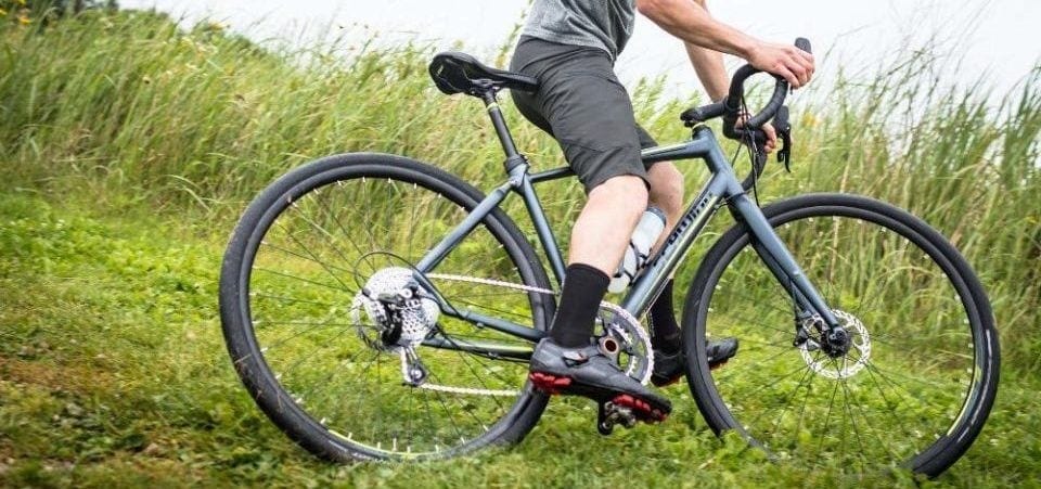 a man with his bike on the grass