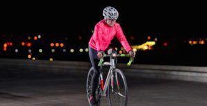 a woman riding her bicycle at night