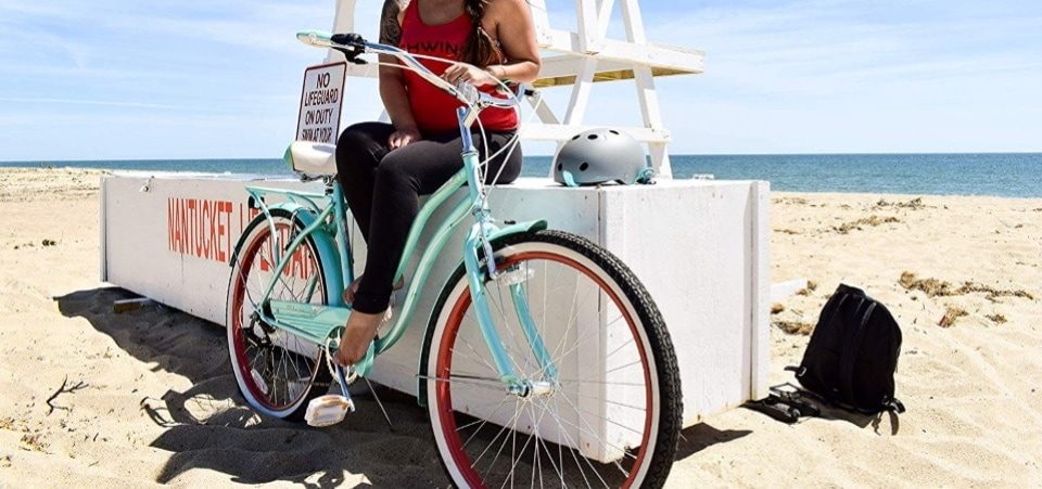 a woman sitting near her hybrid bike on the beach