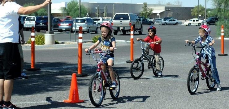 three children learning to use their bikes