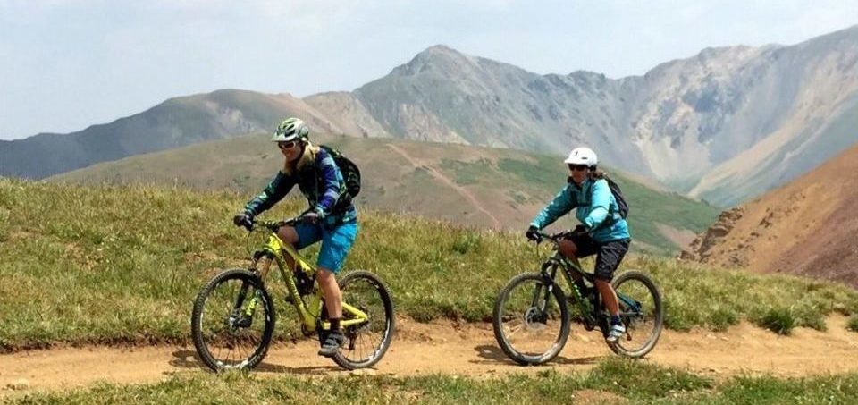 two women riding their bicycles in the hills